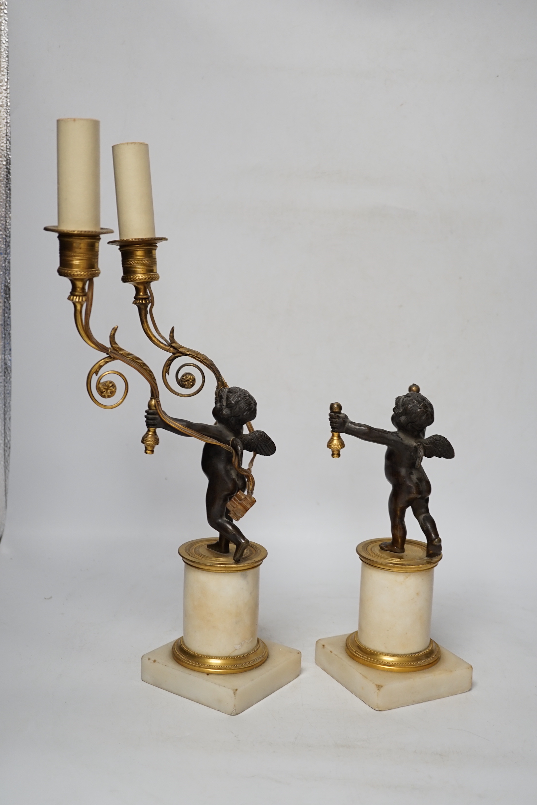 A pair of Louis XVI style bronze, ormolu and alabaster cherub lamps, 42cm high (one a.f.)